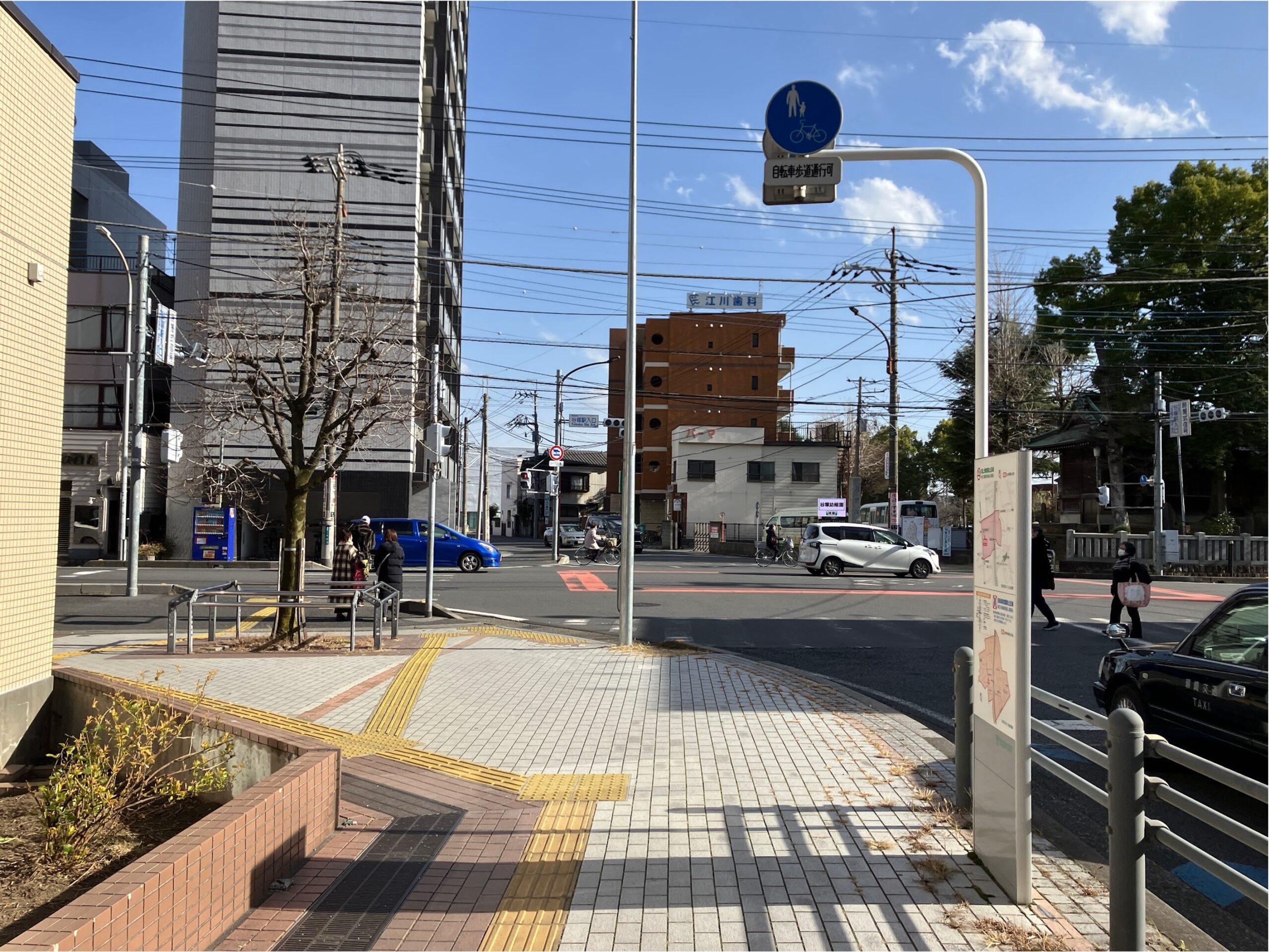 谷塚駅入り口交差点が見えてきます。 交差点の横断歩道を直進します。 車の往来が多いので横断には十分気をつけてください。