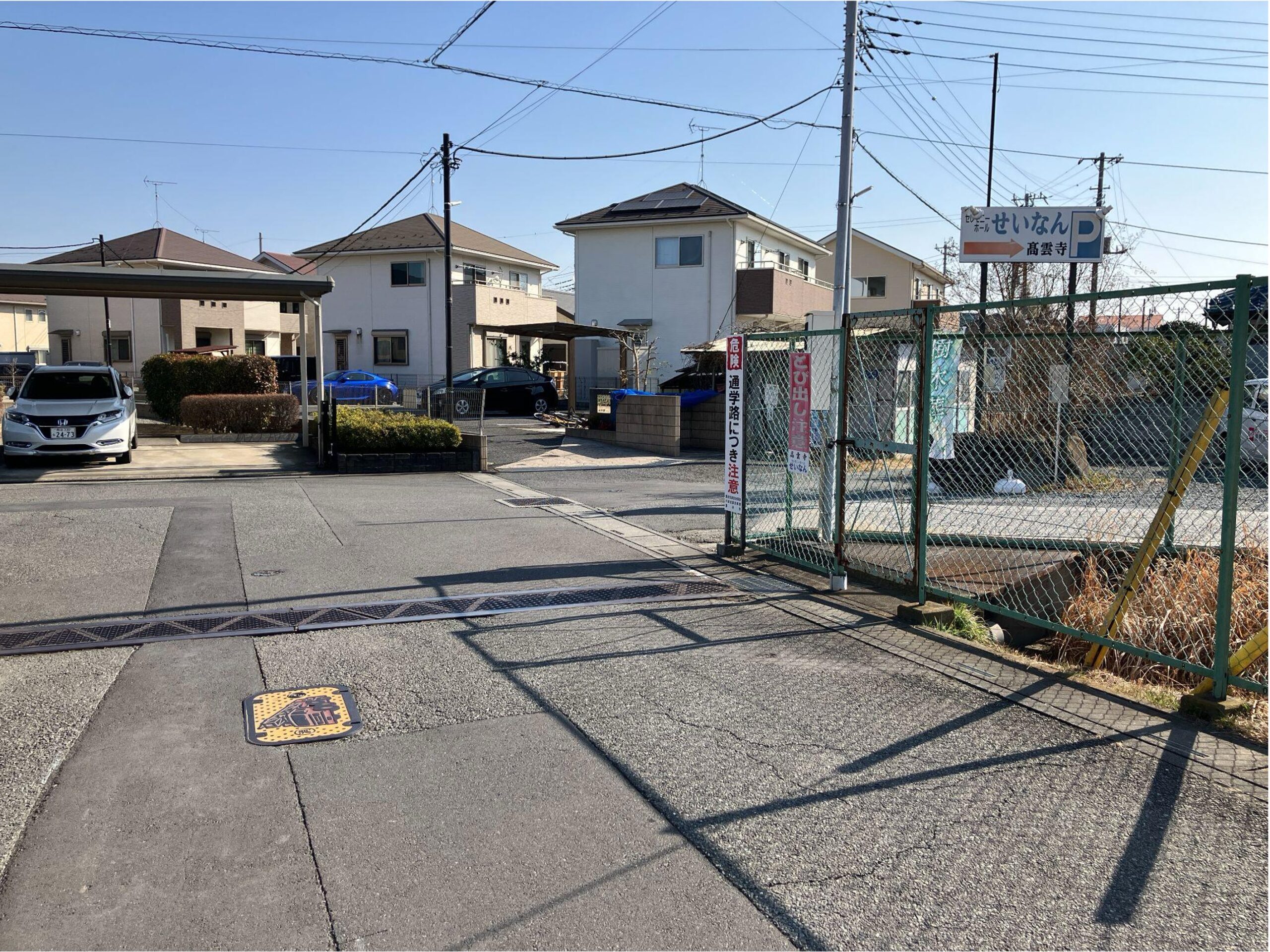 右手緑色のフェンスの端が入り口となります。 こちらを右折します。